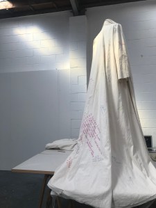 Unbound coat working on the hem on the table beautiful Low res