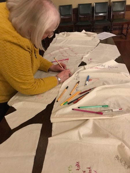 Woman in yellow signing fabric