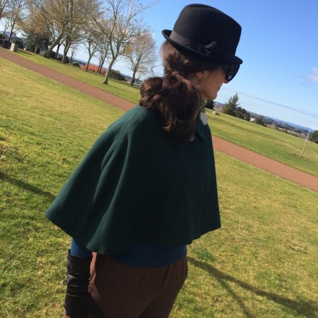 green cape standing side on